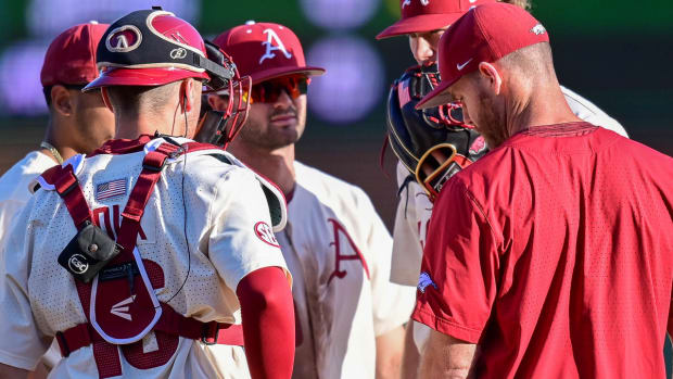 Razorbacks pitching coach Matt Hobbs on mound with infield against UCA